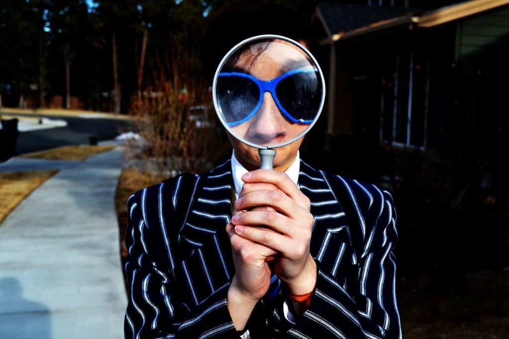 Person holding a big magnifying glass